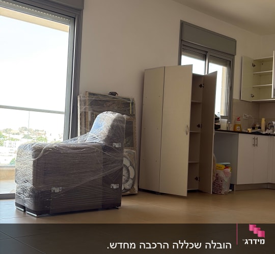 רהיטים עטופים בניילון בחדר ריק עם ארונות פתוחים